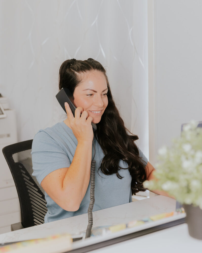 Friendly staff member answering the phone to schedule appointments.