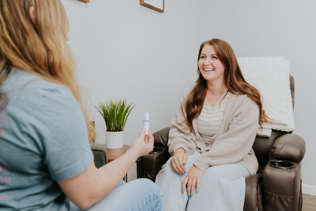 A woman smiles as a provider explains ketamine-based treatment in Gun Barrel City