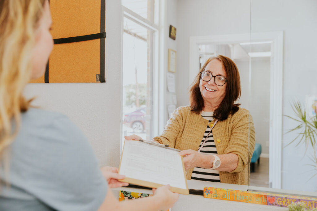 A woman in a yellow cardigan checks in at our office, in time for her consultation for depression and medication in Canton, TX.