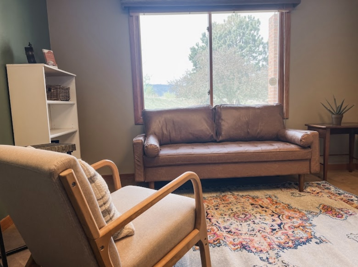 Mental wellness office with couch and chair.