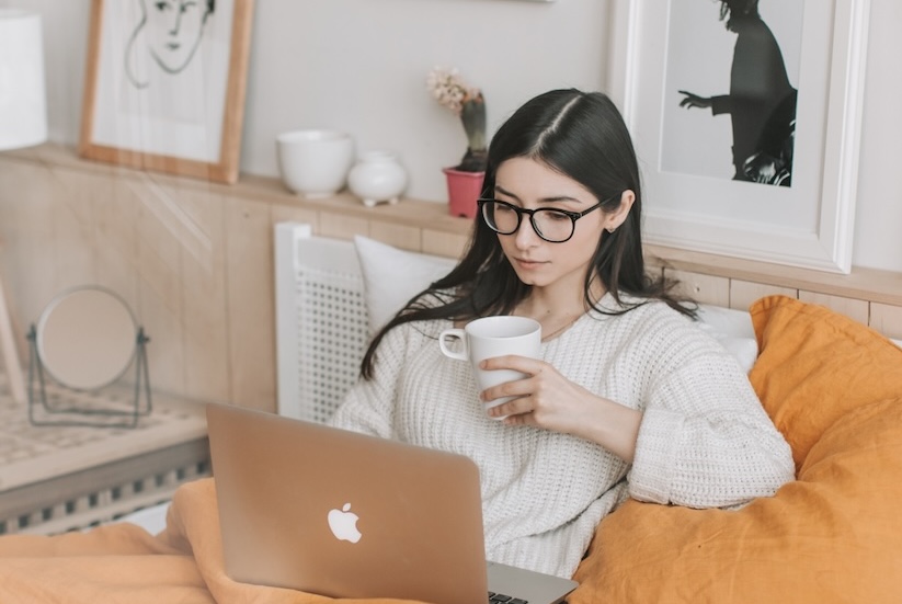 A woman curled up on her couch browses the internet to learn more about signs of depression and medication in Canton, TX.