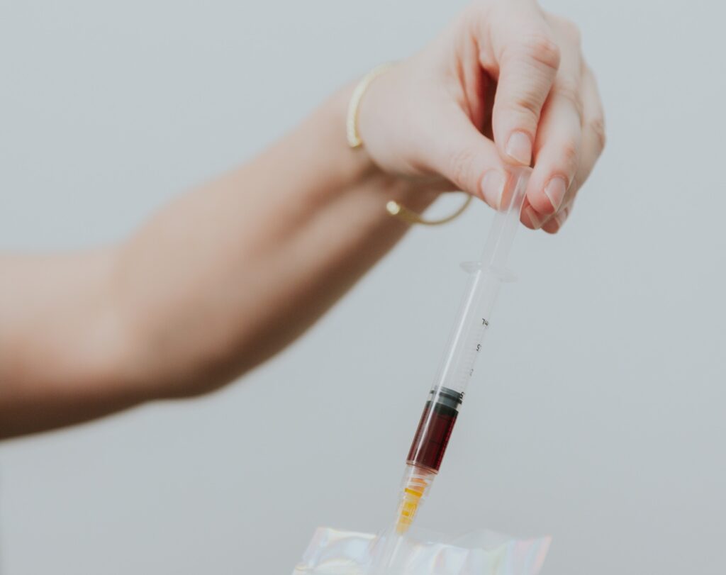 One of our expert providers places a syringe prepped for weight loss injections in Gun Barrel City, TX, into a bag.