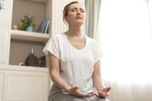 A woman practices mindfulness to address symptoms of ADHD in adults near Forney.