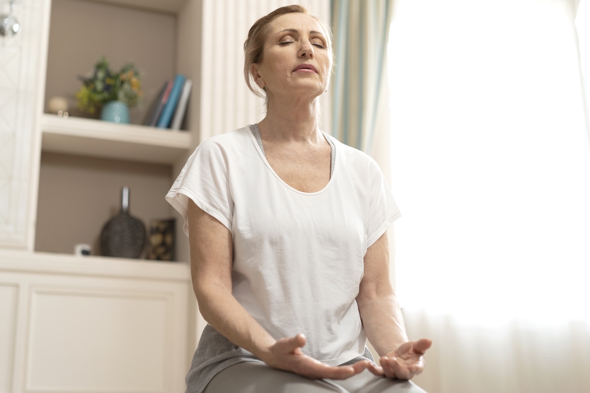 A woman meditates and practices deep breathing techniques for anxiety in Dallas